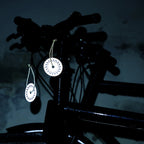 refleks vedhæng på cykel der lyser i mørket og øger synlighed i trafikken