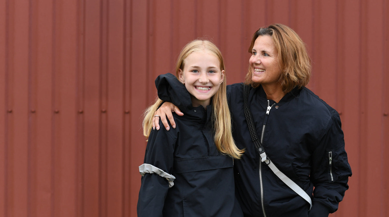 mor og barn med refleks taske strap der øger synlighed i trafikken