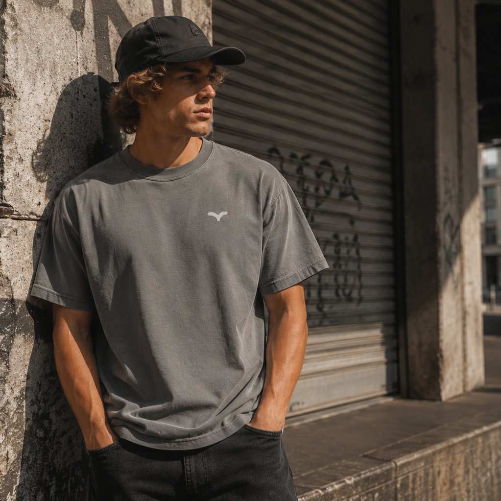 Person iført grå Endless Hope T-shirt med lille reflekslogo på brystet. T-shirten kombinerer et minimalistisk design med komfort og et afslappet, urbant udtryk.