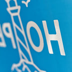 Detalje af reflekstryk med HOPE motiv på blå hoodie