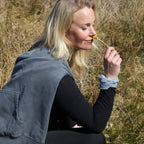 Kvinde i naturen med refleks-scrunchie fra Safe & Shine på håndleddet – funktionel accessory til hverdag og bevægelse