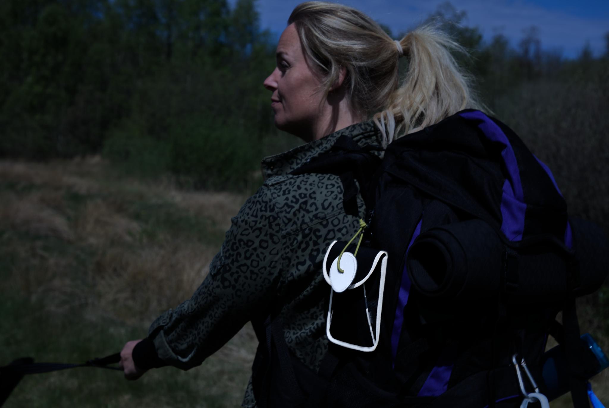 Kvinde på aftentur med rygsæk, Galaxy taske og refleksvedhæng fra Safe & Shine i mørke omgivelser