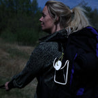 Kvinde på aftentur med rygsæk, Galaxy taske og refleksvedhæng fra Safe & Shine i mørke omgivelser