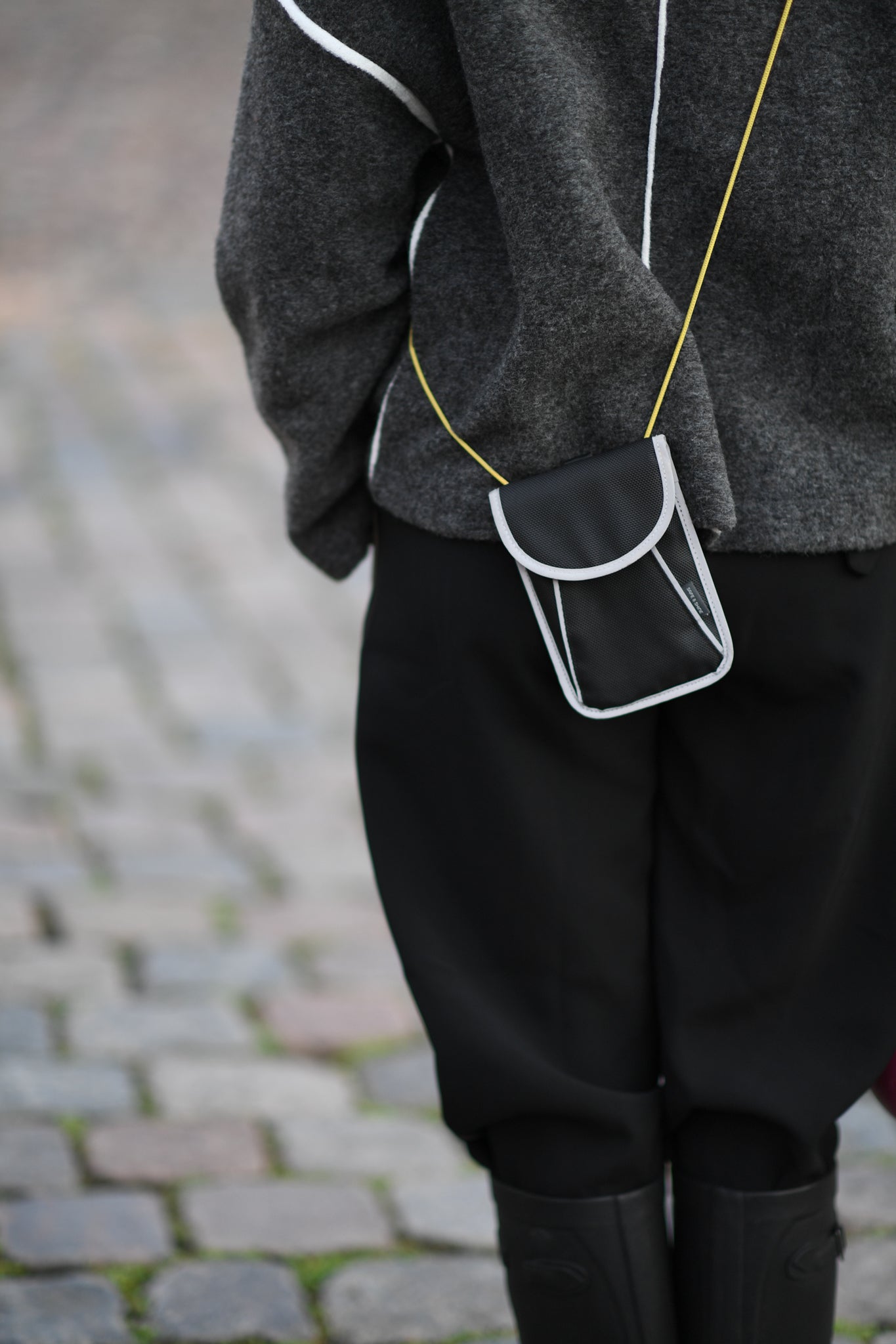 A person goes out on the town with a reflective bag strap for everyday use