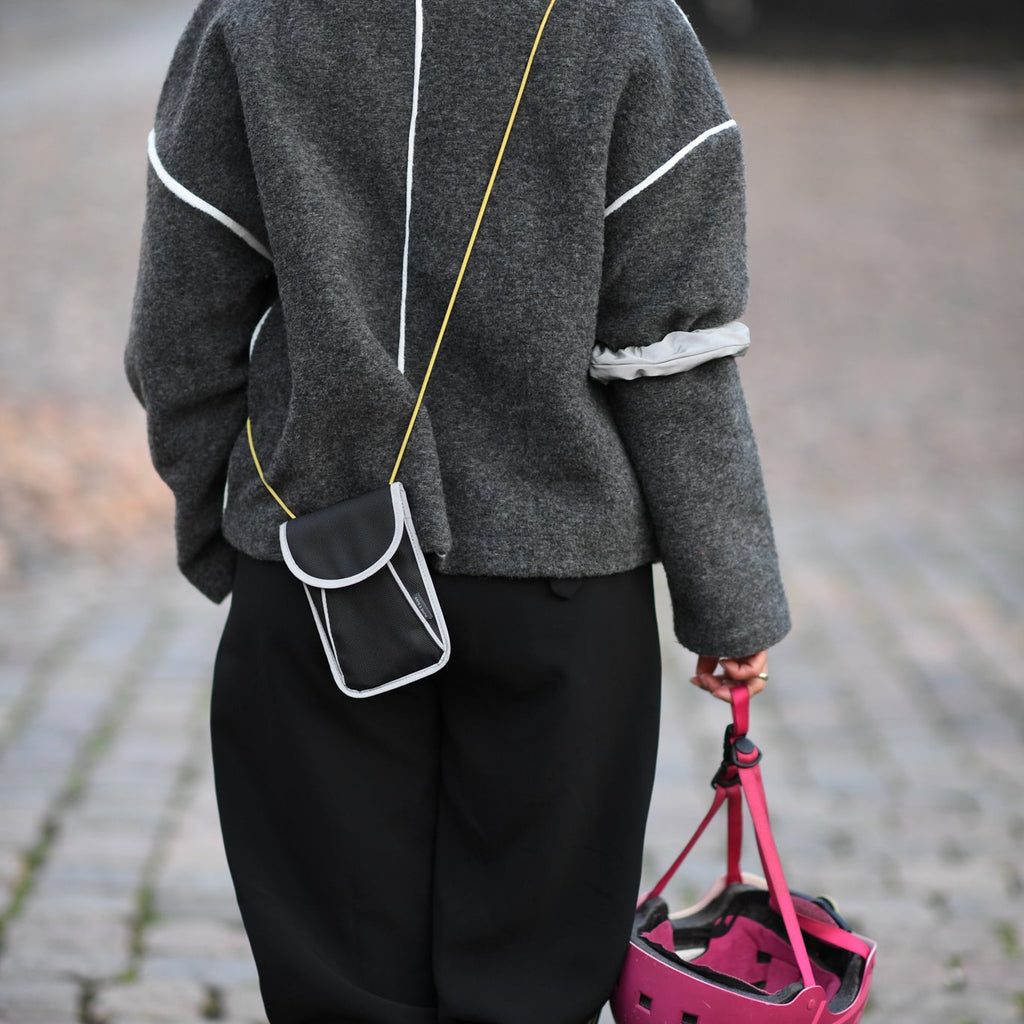 A person goes out on the town with a reflective bag strap for everyday use