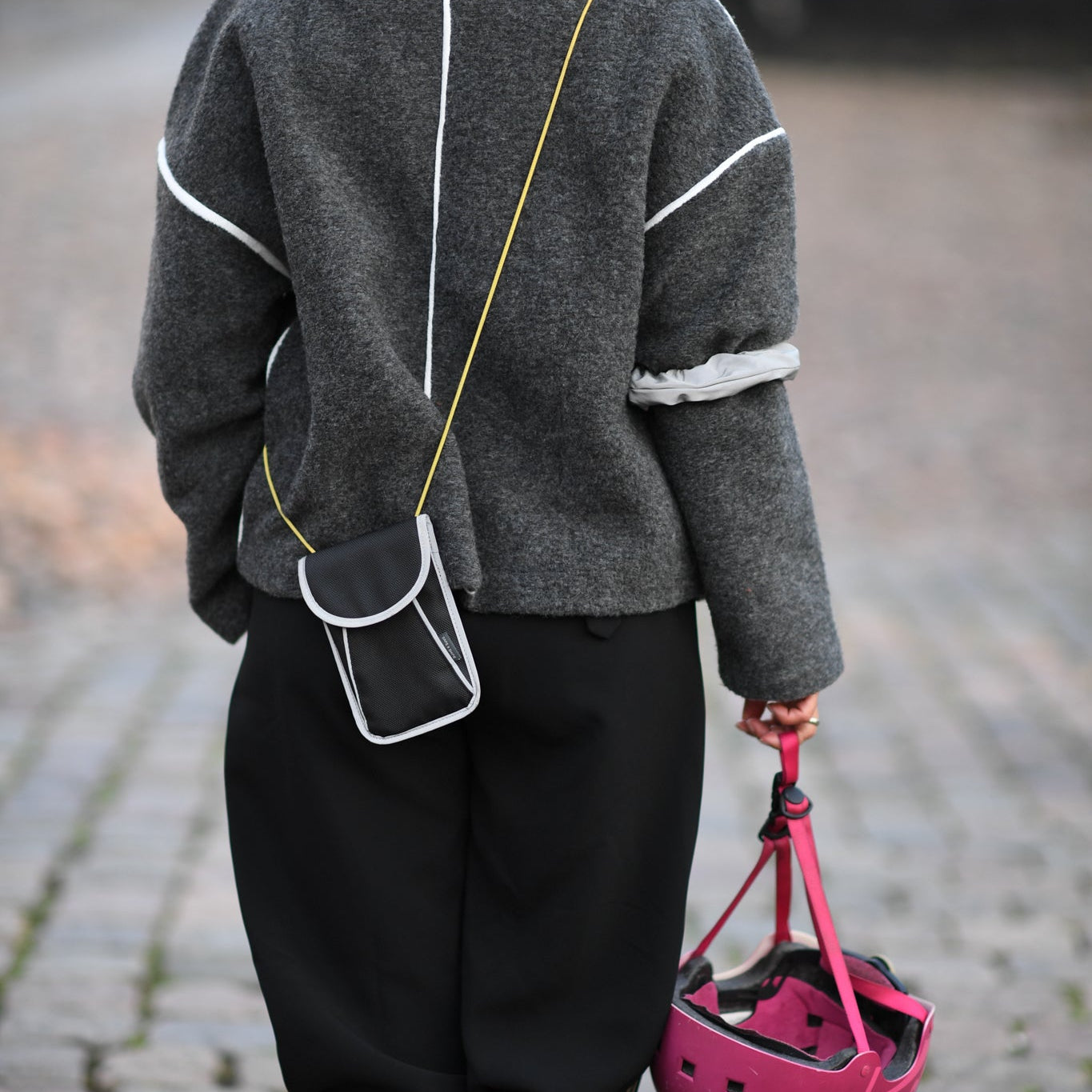 A person goes out on the town with a reflective bag strap for everyday use