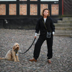 person med refleks taske strap og hund der øger synlighed i trafikken i hverdagen