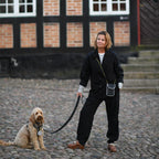 A person wearing a reflective bag strap and a dog, which increases visibility in everyday traffic