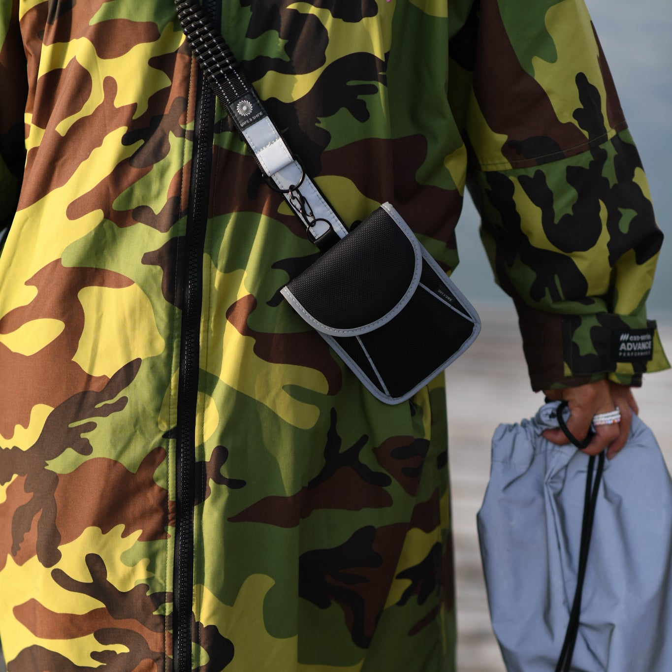 A person wearing a reflective strap during everyday activities by the water