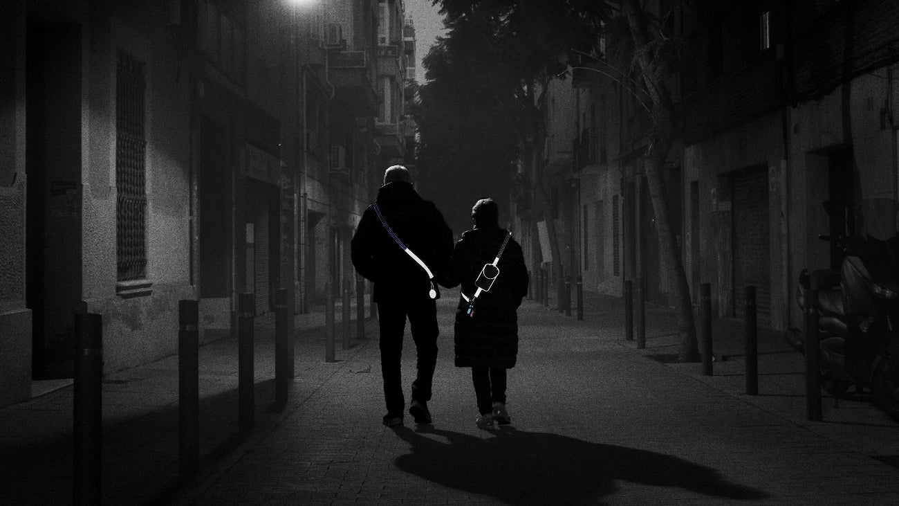 Dame og mand går tur i mørket med reflekser