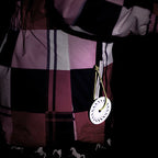 refleks vedhæng på jakke der lyser i mørket og gør barnet synligt i trafikken